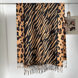 Detalle de bufanda de invierno con estampados de leopardo y cebra y bordes de flecos