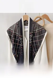 Detail of navy blue geometric print triangle scarf styled over a white shirt