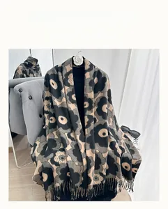 Detail of flower pattern on thick winter scarf with fringed edges in camel and black