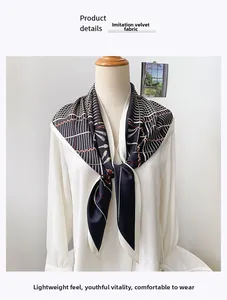 Detail view of black and white geometric silk scarf draped on a fashion mannequin