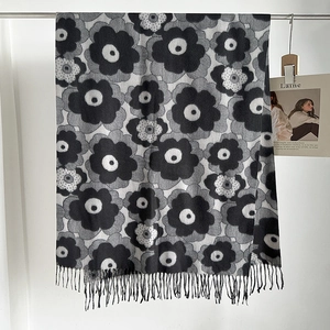 Close-up of black and white poppy flower printed scarf with elegant tassel fringe details