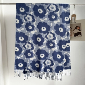 Detail of blue and white floral poppy pattern on soft thick winter scarf with fringe edges