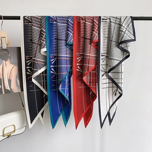 Vintage patterned silk scarves in navy, blue, red and beige draped on a display rack