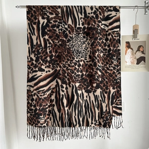 Detailed view of leopard print scarf with fringe edges in soft faux cashmere fabric