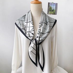 Elegant vintage silk scarf with black and white geometric chain print tied on a white shirt