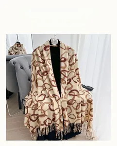 Close-up of beige pashmina shawl with brown ring chain patterns and fine fringe details