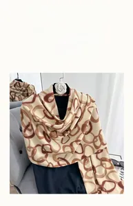 Detail of soft beige cashmere-like scarf with brown geometric circle print on hanger