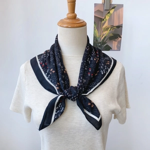 Vue détaillée d'un foulard en soie fleurie avec base noire et motifs rouges et blancs