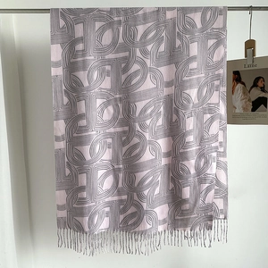 Close-up of pink and grey faux cashmere scarf with geometric jacquard patterns and tassels