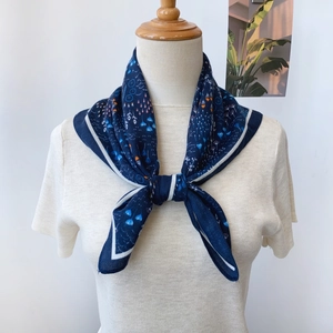Détail d'un foulard en soie à fleurs bleu marine avec d'élégants imprimés abstraits