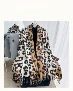 Close-up of leopard print scarf with black tassels hanging on a chair for autumn