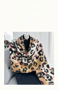 Macro shot of soft leopard print faux cashmere scarf showing fabric texture and pattern