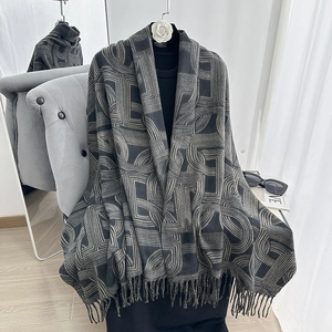 Detail of thick cashmere scarf with geometric jacquard patterns and elegant tassels
