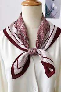 Detail shot of a bohemian red and white herringbone pattern square scarf on a mannequin