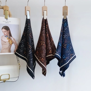 Carré de soie à imprimé floral en noir, marron et bleu marine sur cintres en bois