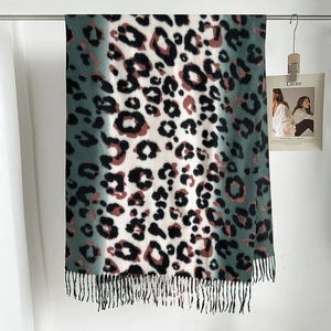 Detail of soft leopard print scarf featuring rich green tones and dense fringe tassels