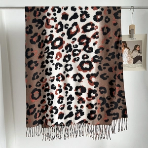 Close-up of leopard print scarf with soft cashmere-like texture and long tassel fringe details