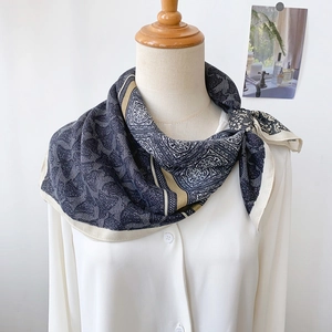 Elegant grey paisley silk square scarf with vintage pattern worn on a white blouse