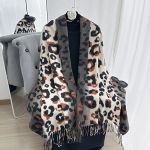 Detailed view of leopard print pashmina shawl featuring fine fringe trim and thick texture