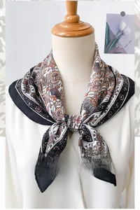 Detail of herringbone patterned square scarf showing elegant drape and paisley print