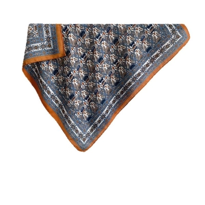 Square silk scarf with blue and orange paisley pattern folded in a triangle