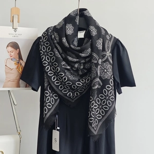 Détails macro d'une écharpe à motifs floraux géométriques noir et blanc et franges
