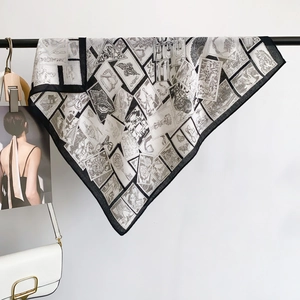 Vintage style black and white square silk scarf with stamp and floral prints on a rack