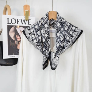 Detail of silk-like neckerchief with geometric lines on a white shirt and wooden hanger