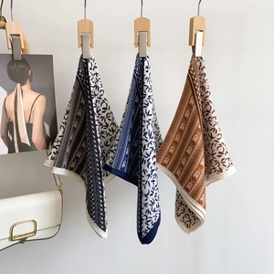 Elegant printed square scarves in black blue and brown patterns for women hanging on wall