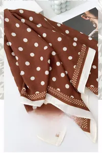 Detail of brown polka dot square scarf with herringbone texture and geometric borders