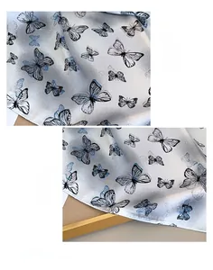 Detailaufnahme des Seidenschals mit Schmetterlingsdruck, feinem Rollsaum und elegantem Muster