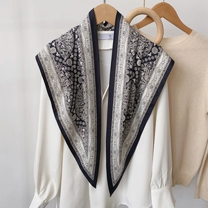 Élégant foulard en soie à motif paisley noir et blanc sur une chemise et un cintre en bois