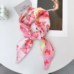 Detail eines Seidentuchs mit Schmetterlingsdruck in Rosa-Gelb-Verlauf als Schleife