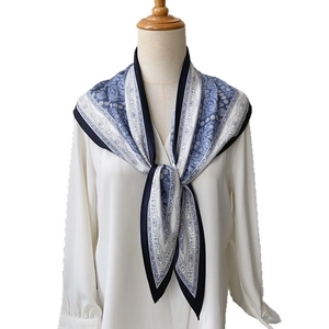 Foulard triangulaire à motif cachemire bleu et blanc sur une chemise blanche