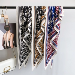 Classic checkered silk scarf with geometric patterns hanging on a minimal display