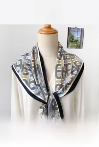 Détail de texture d'un foulard triangulaire satiné à motifs de chaînes géométriques bleues