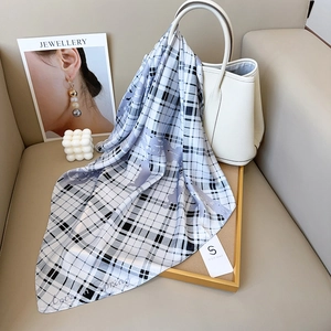 Foulard en satin à carreaux avec motif de cheval drapé sur un sac à main blanc chic