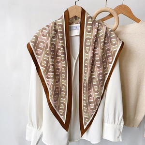 Foulard triangle en soie à imprimé chaîne drapé sur une chemise blanche pour un look élégant