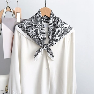 Détail d'un foulard en soie vintage noué sur une chemise blanche à manches longues