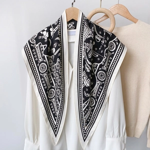 Elegant black and white geometric print silk scarf displayed on a wooden hanger
