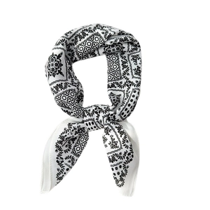 Carré de soie tendance pour femme avec imprimé paisley noir et blanc noué élégamment