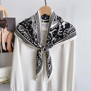 Detail of a white silk shirt with a black and white geometric pattern neck scarf