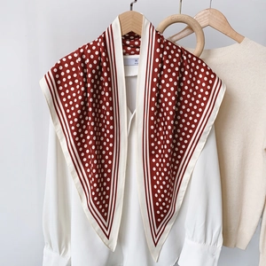Retro red and white polka dot silk scarf tied over a white silk shirt on a hanger