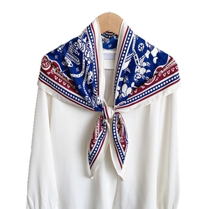 Elegant silk scarf with red and blue plaid patterns styled on a white shirt