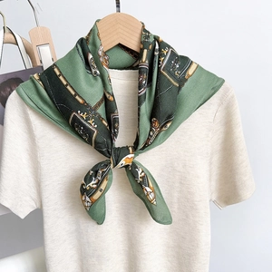 Elegant dark green silk square scarf featuring gold chain prints on a wooden hanger