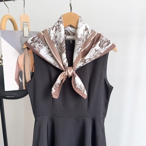 Détail d'un foulard en soie vintage avec imprimé architectural noué au cou