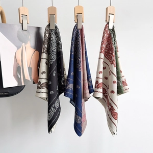Eleganti foulard in seta con motivo paisley in quattro colori appesi con decorazioni