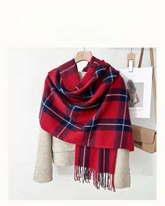 Detail of red and blue checkered scarf with long tassels draped on a beige blazer