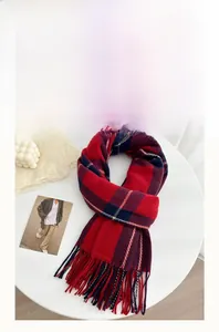 Detail of red and blue plaid scarf showing plush faux cashmere texture and thick fringe