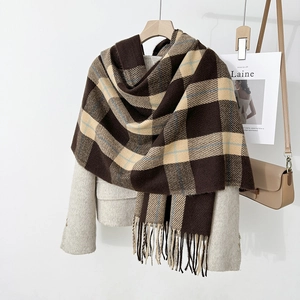 Detail of soft thick scarf with brown and beige plaid pattern and fringe tassels